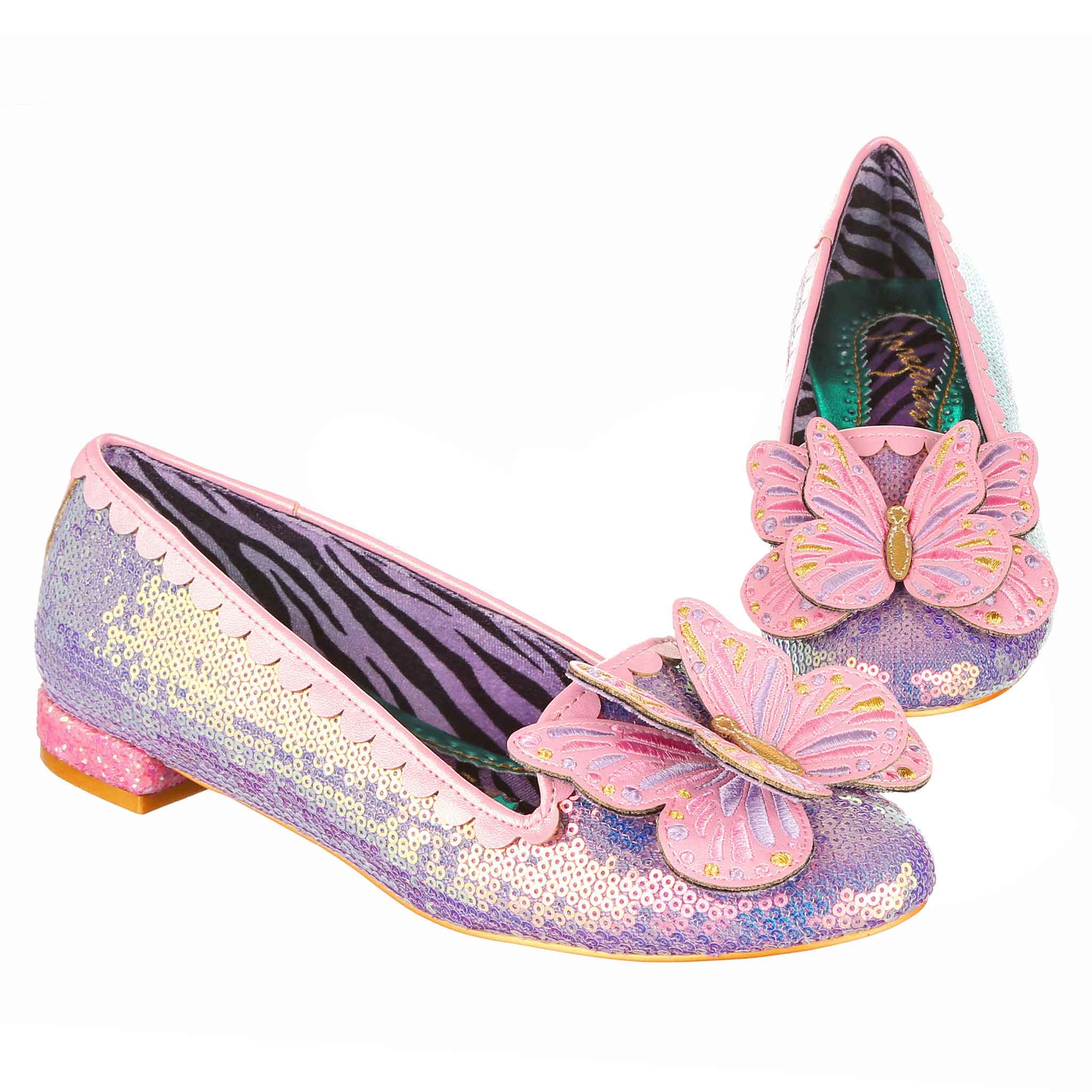 A pair of lilac sequin flat ballet pumps with pink butterfly's on the toe on a white background.