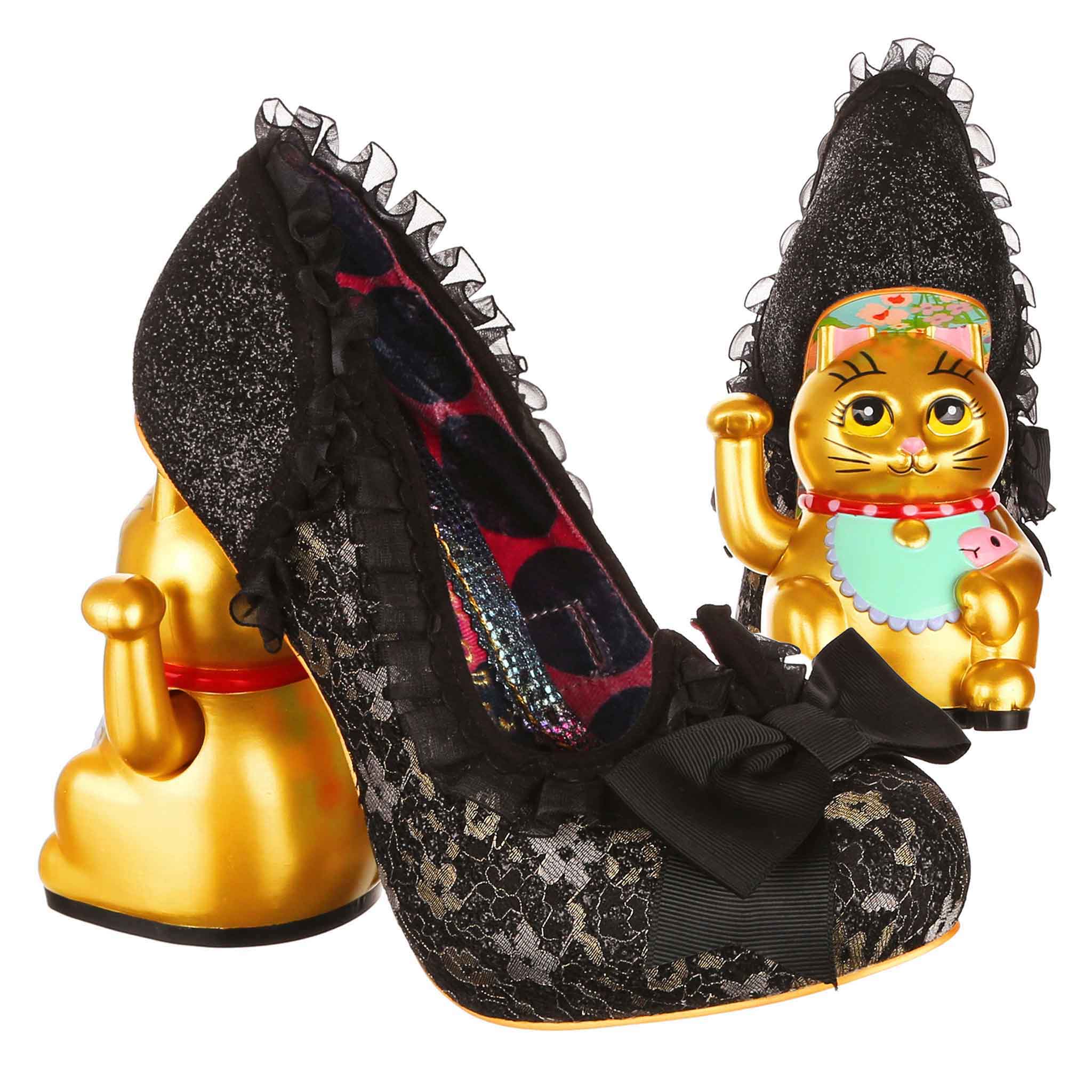 Black lace high-heeled shoe with decorative elements and gold cat figurine concept heel on a white background